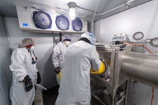 Three scientists process frozen Apollo 17 samples in a walk-in freezer.