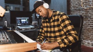 Man writes down lyrics in his studio