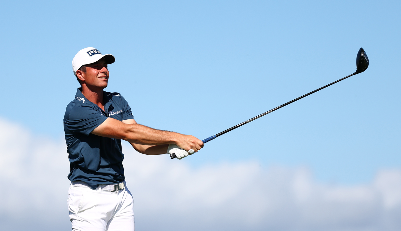 Viktor Hovland hits a tee shot and watches it