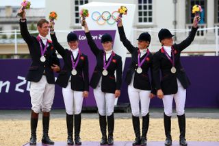 The Great Britain team celebrate on the podium after winning the Silver medal in the Eventing Team Jumping Final Equestrian event on Day 4 of the London 2012 Olympic Games