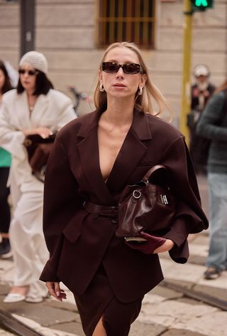 A woman wearing the wine red color trend during Milan Fashion Week spring/summer 2025.