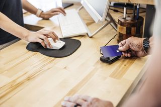 Senior male patient paying through credit card at reception desk in medical clinic - stock photo