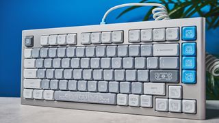 The NuPhy Nos75 mechanical keyboard on a stone surface with a blue background