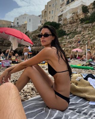 French girl's holiday wardrobe: @leiasfez wears a simple black string bikini while sunbathing