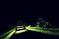 Lawn At Night With A Light Shining Through A Lawn Chair