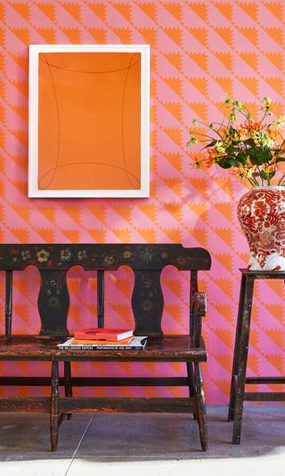 graphic orange and pink wallpaper with wooden bench