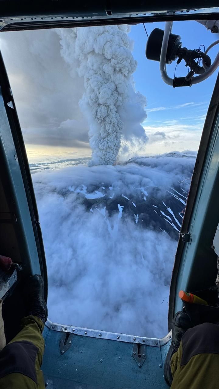 A photograph of ash erupting from Krasheninnikov volcano, taken from inside of a helicopter.