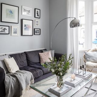 living room with grey wall and glass table with flower on glass jar