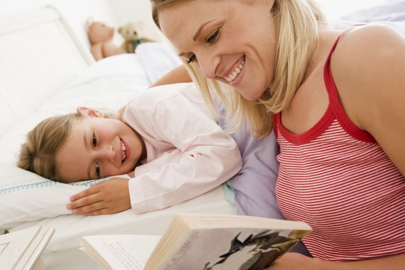 A mom reads a bedtime story to her daughter.