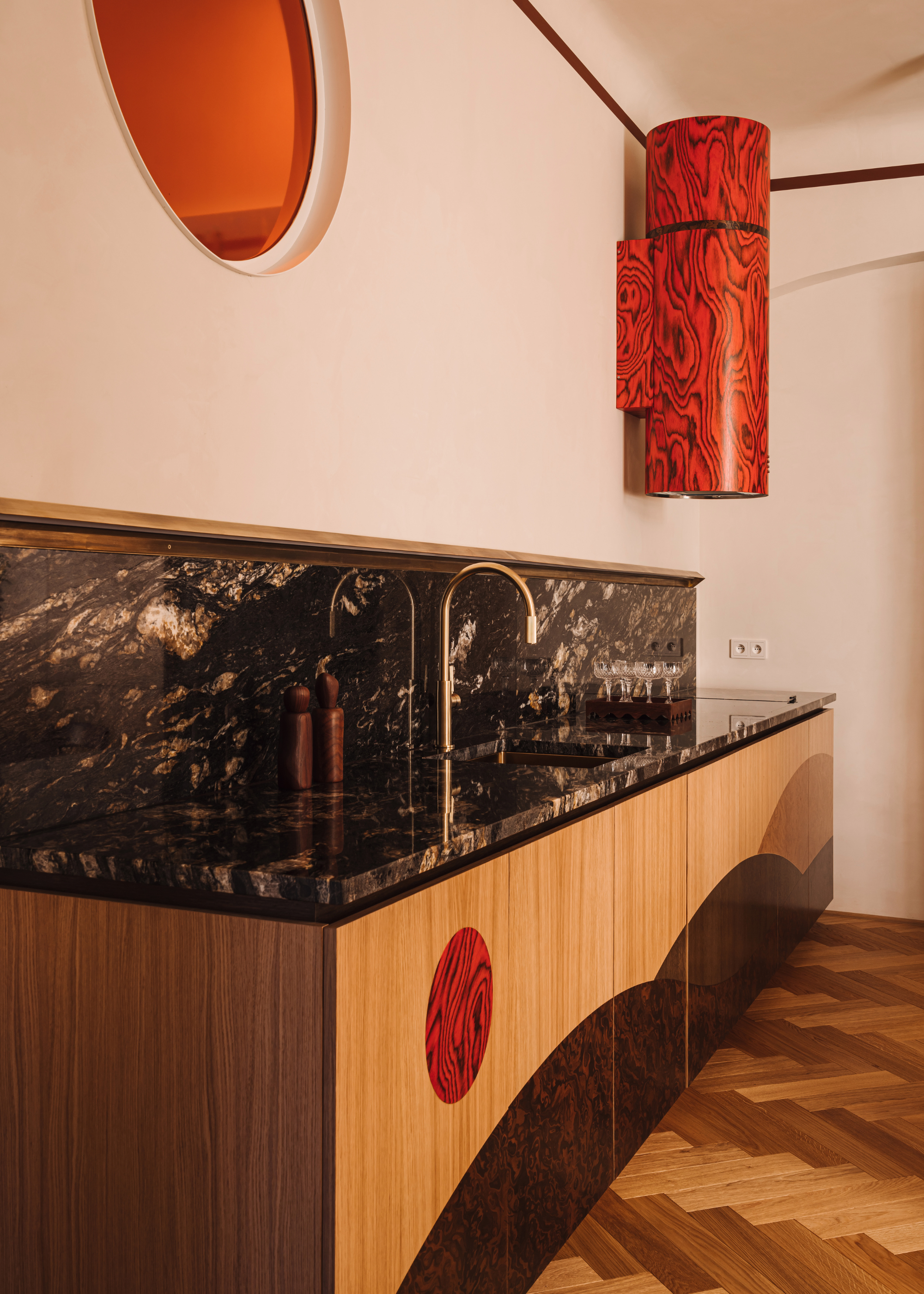cool kitchen with red veneer details and black marble counters