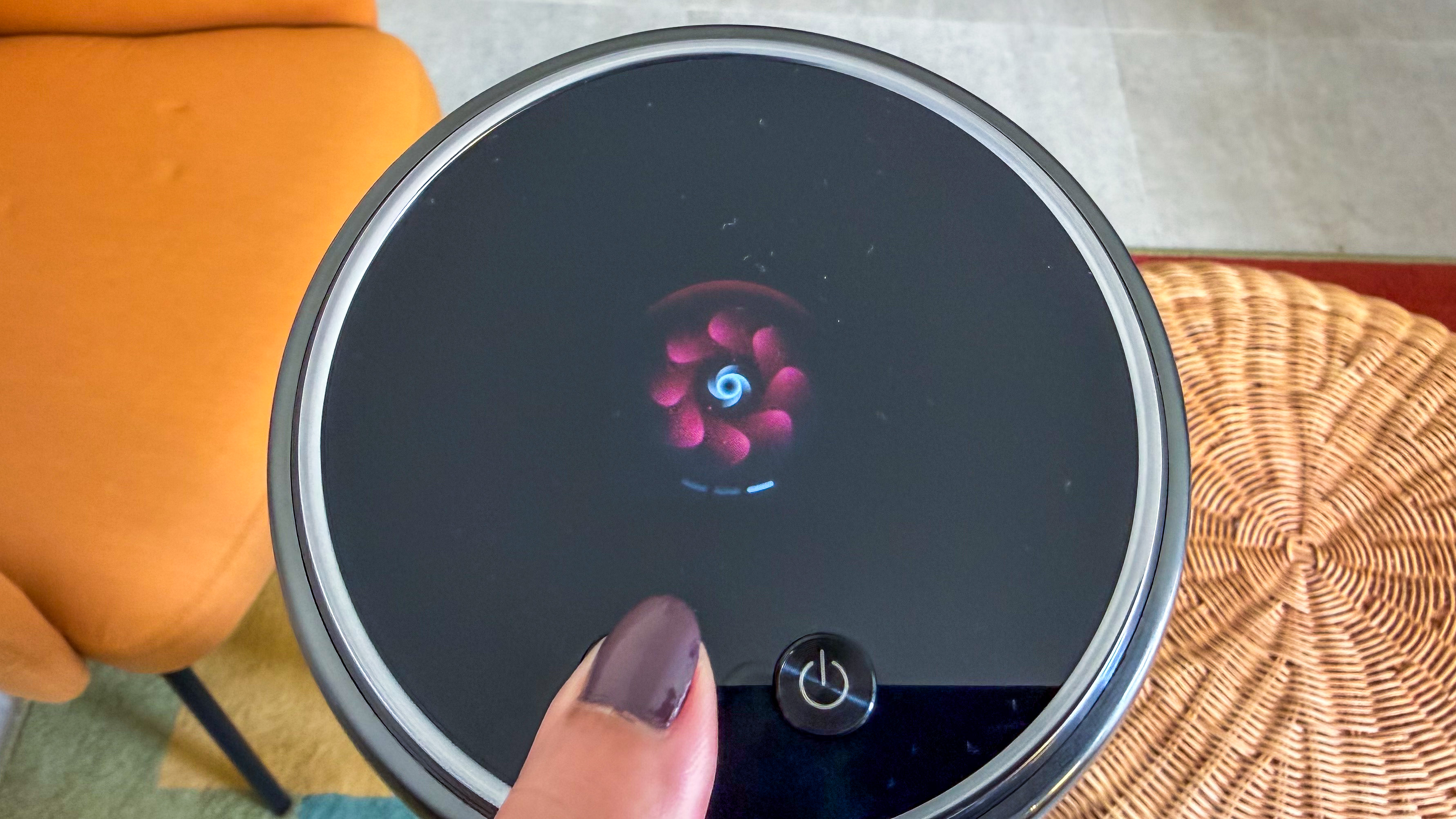 A thumb pressing the suction button on the Dreame Z50 Station