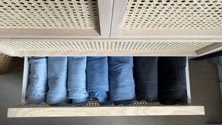 Jeans storage in a dresser showing different colored jeans stored in a file format.