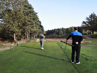 A two-ball playing golf on the tee box