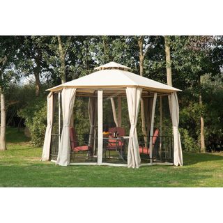 Cream colored enclosed gazebo design with curtains on a lawn