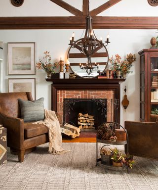 A brown living room with terracotta brick fireplace, round framed mirror, brown leather armchairs