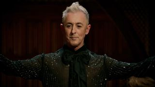 Alan Cumming in all black hosting Peacock's The Traitors season 2