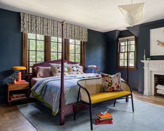 bedroom painted dark blue with white ceiling and light gray rug