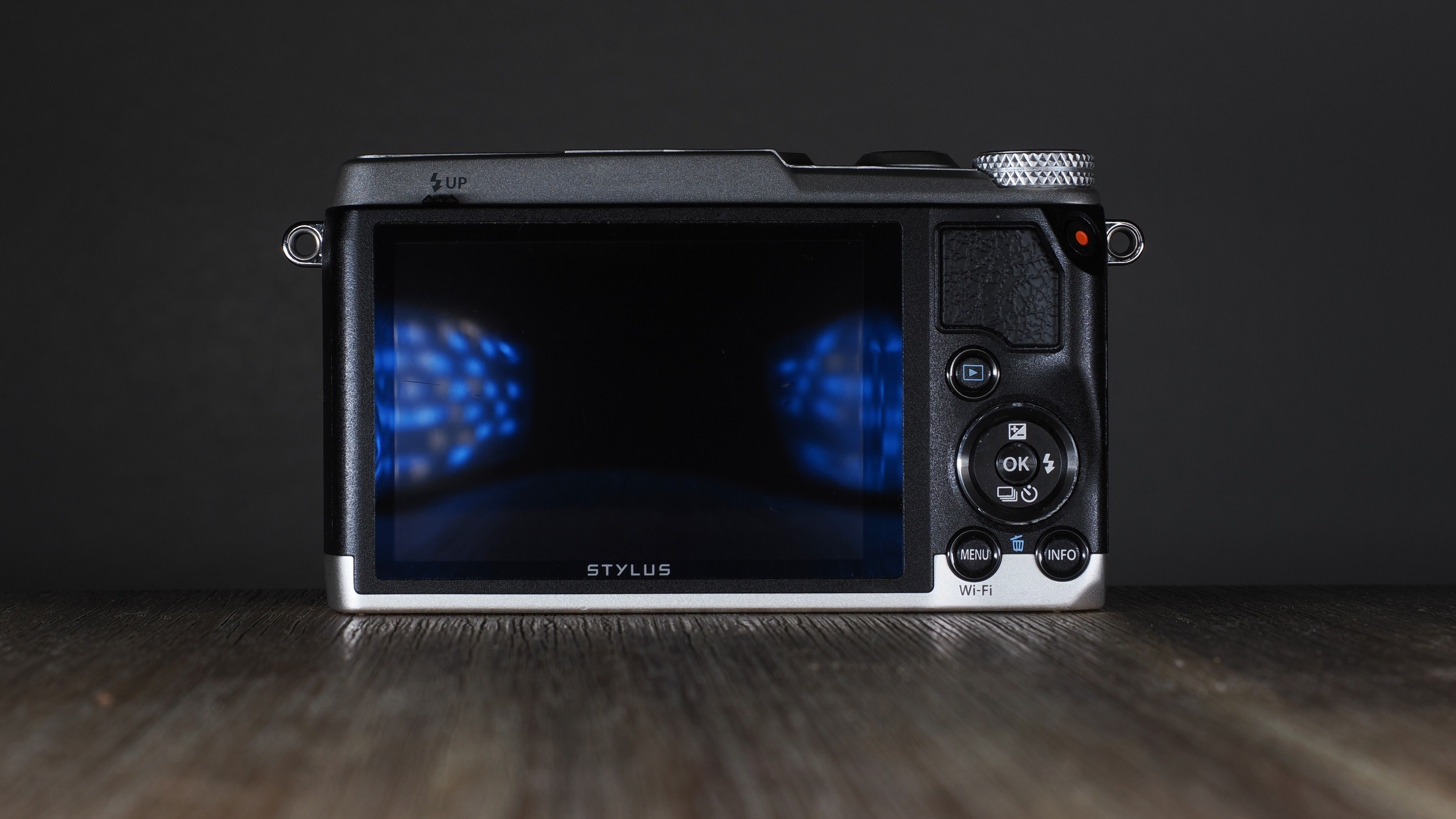 Olympus Stylus SH-3 on a wooden surface