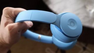 A photo of someone holding the Beats Solo headphones in blue.