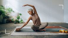 Woman doing yoga in studio, stretching over to one side after learning how often should you do yoga