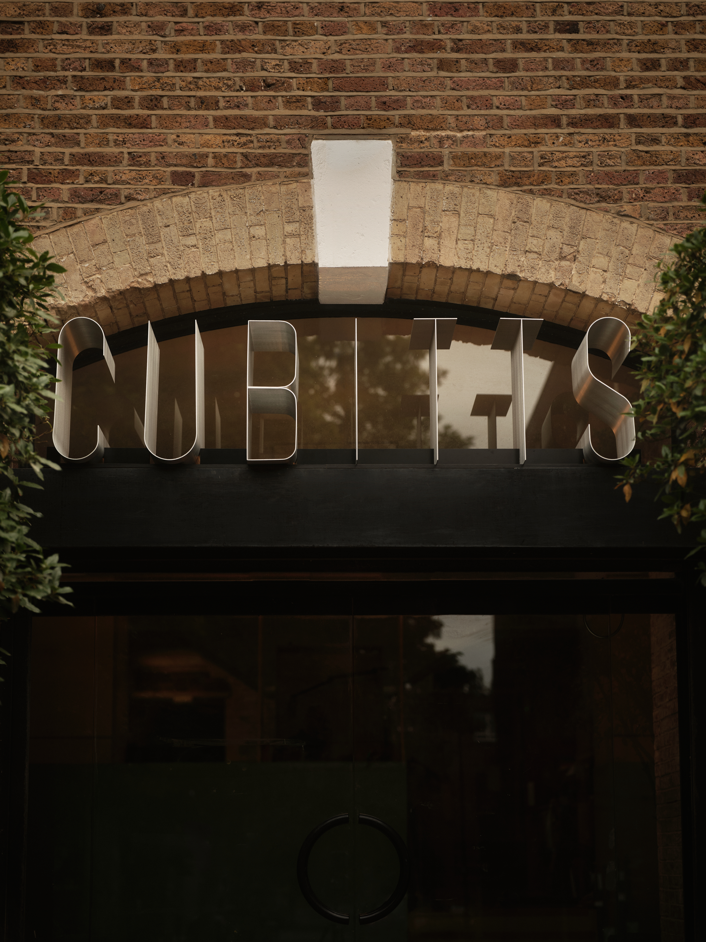 new Cubitts headquarters interior, refurbished warehouse type building with raw materiality and colour pops