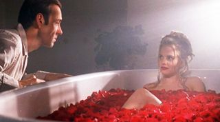 mena suvari in a bath of roses with kevin spacey sitting to the side
