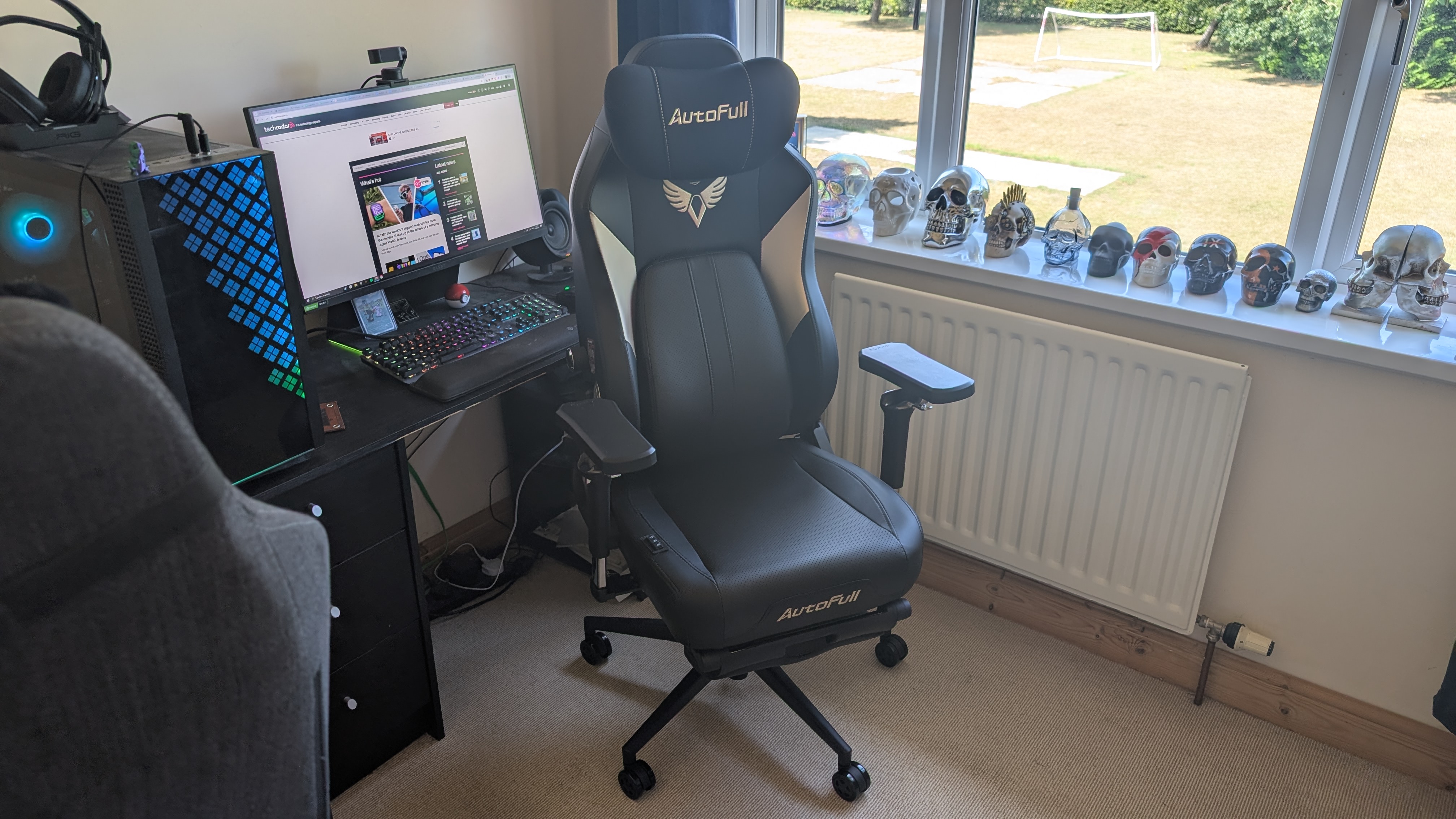 The AutoFull M6 Ultra gaming chair pictured in front of a desk with a gaming PC setup.