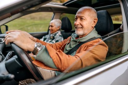 Elderly couple driving in car. 