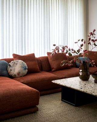 a living room with burnt orange couch