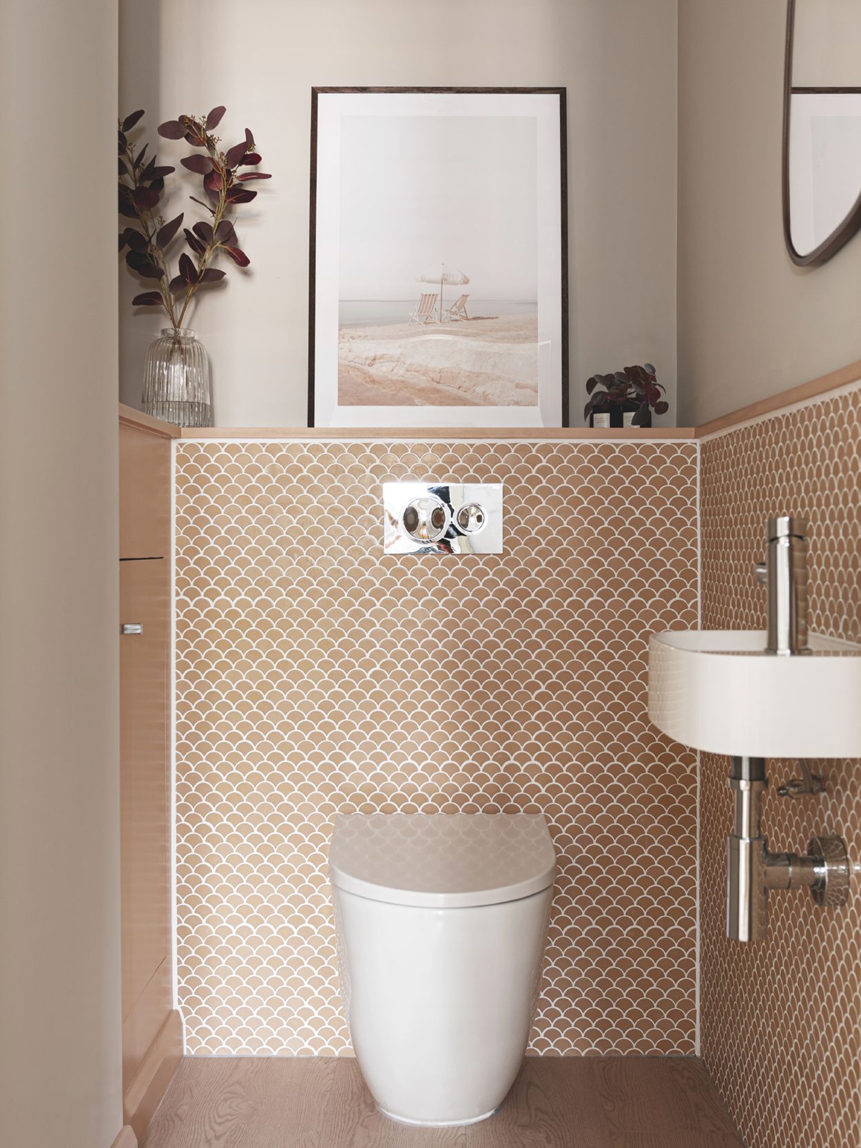 A small bathroom with soft pink tiles