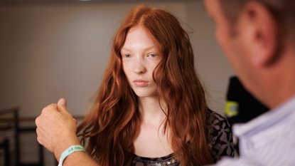 Redhead model getting her hair touched up backstage at Roberto Cavalli spring 2025 show 