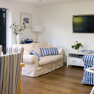 living room with cream sofa photo frame on wall and flower vase