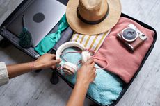 Woman packing a suitcase to go on holiday