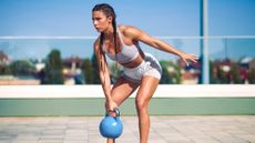 Woman performing a kettlebell swing outside