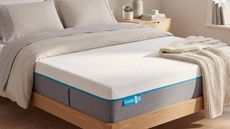 Simba mattress on wooden bed frame with neutral bedding and wooden bedside tables
