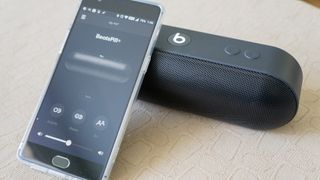 Beats Pill Plus with an iPhone leaning on it