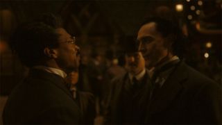 Image from the Marvel T.V. show Loki, season 2 episode 3. Two smartly dressed gentlemen are facing each other and having a confrontation. Just behind them is another man dressed in a nice suit and black hat who is watching the situation unfold.