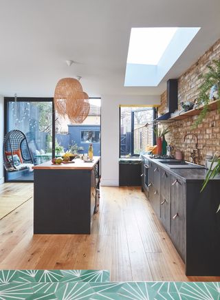black modern kitchen extension with sliding doors and rooflight