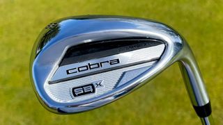 The Cobra Snakebite X wedge resting on the golf course ready to chip onto the greens