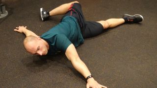 Rich Tidmarsh demonstrates the scorpion stretch for runners