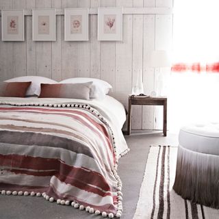 bedroom with grey rustic walls and peach bed linen