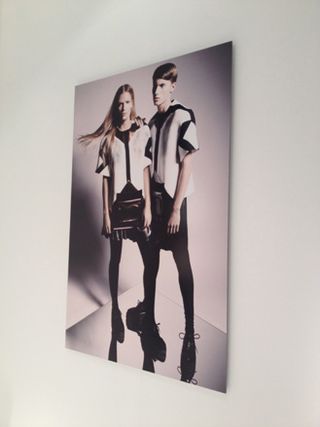 White wall, large canvas print of a young male and female model wearing futuristic uniforms