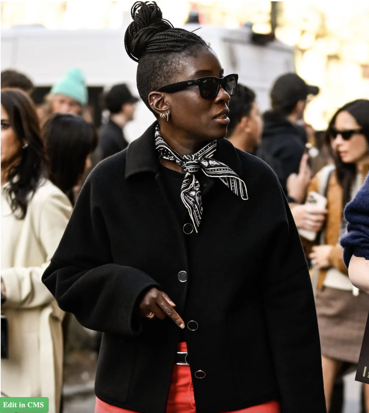 Nikki Ogunnaike wearing a black coat and red pants