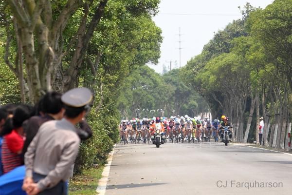 Spectators wait for the peloton