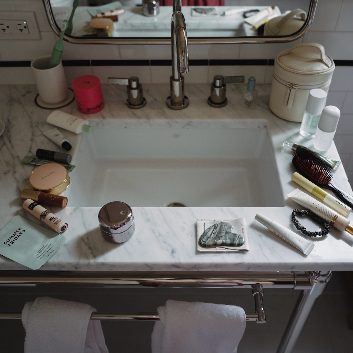Bathroom vanity covered in beauty products