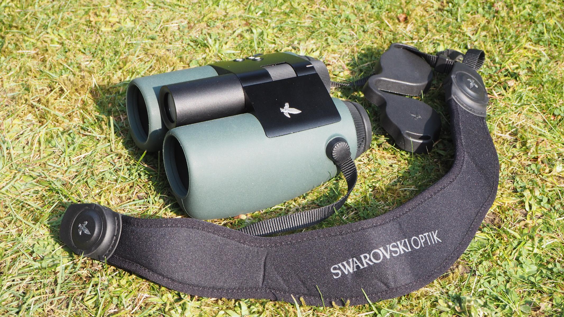 A pair of Swarovski Optik AX Visio smart binoculars, on grass.