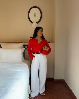 Monique Dale wears J.Crew white linen trousers, red top and sandals.