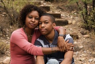 a mom hugs her teenage son