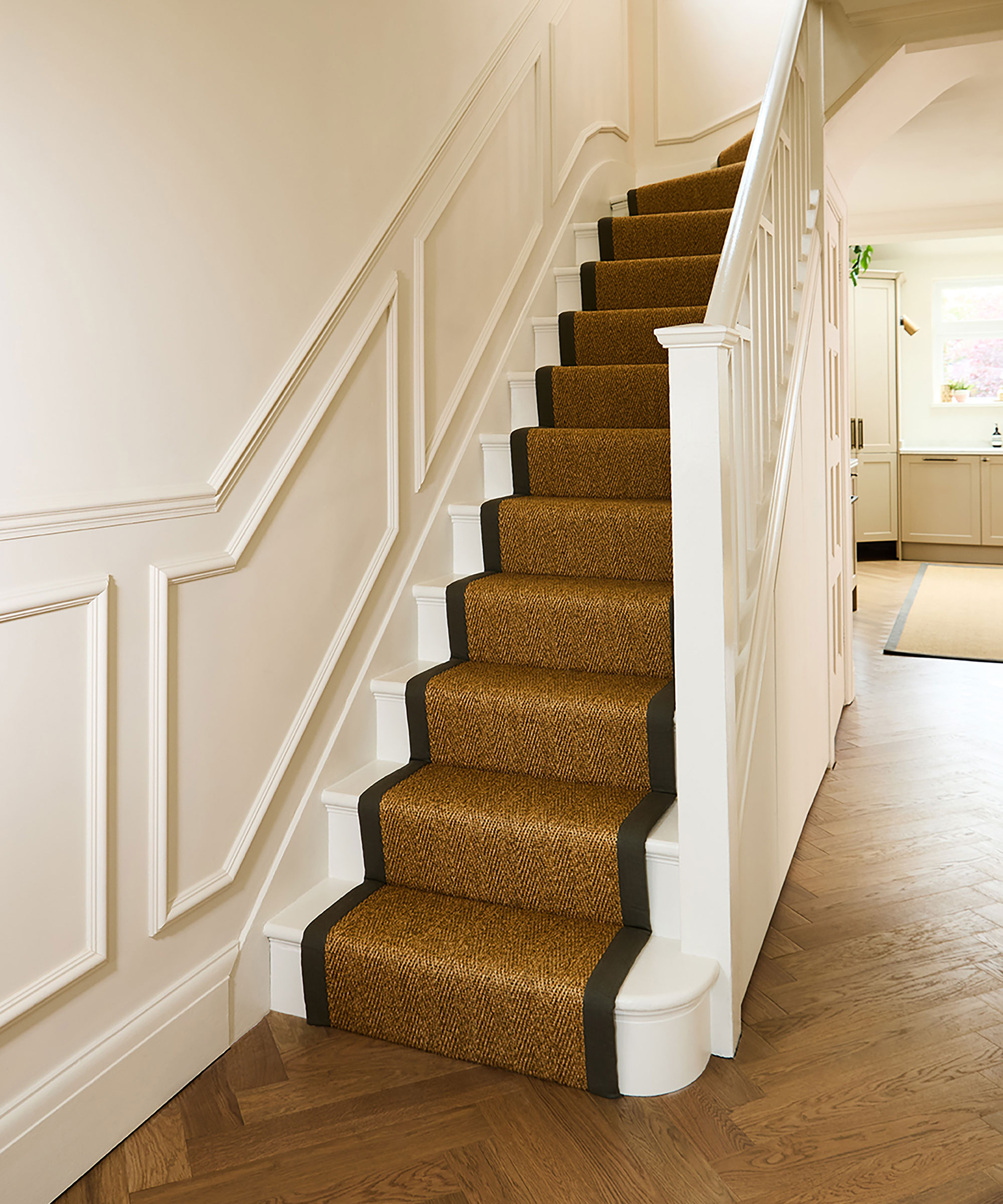 white painted classic staircase with jute runner and half wall panelling
