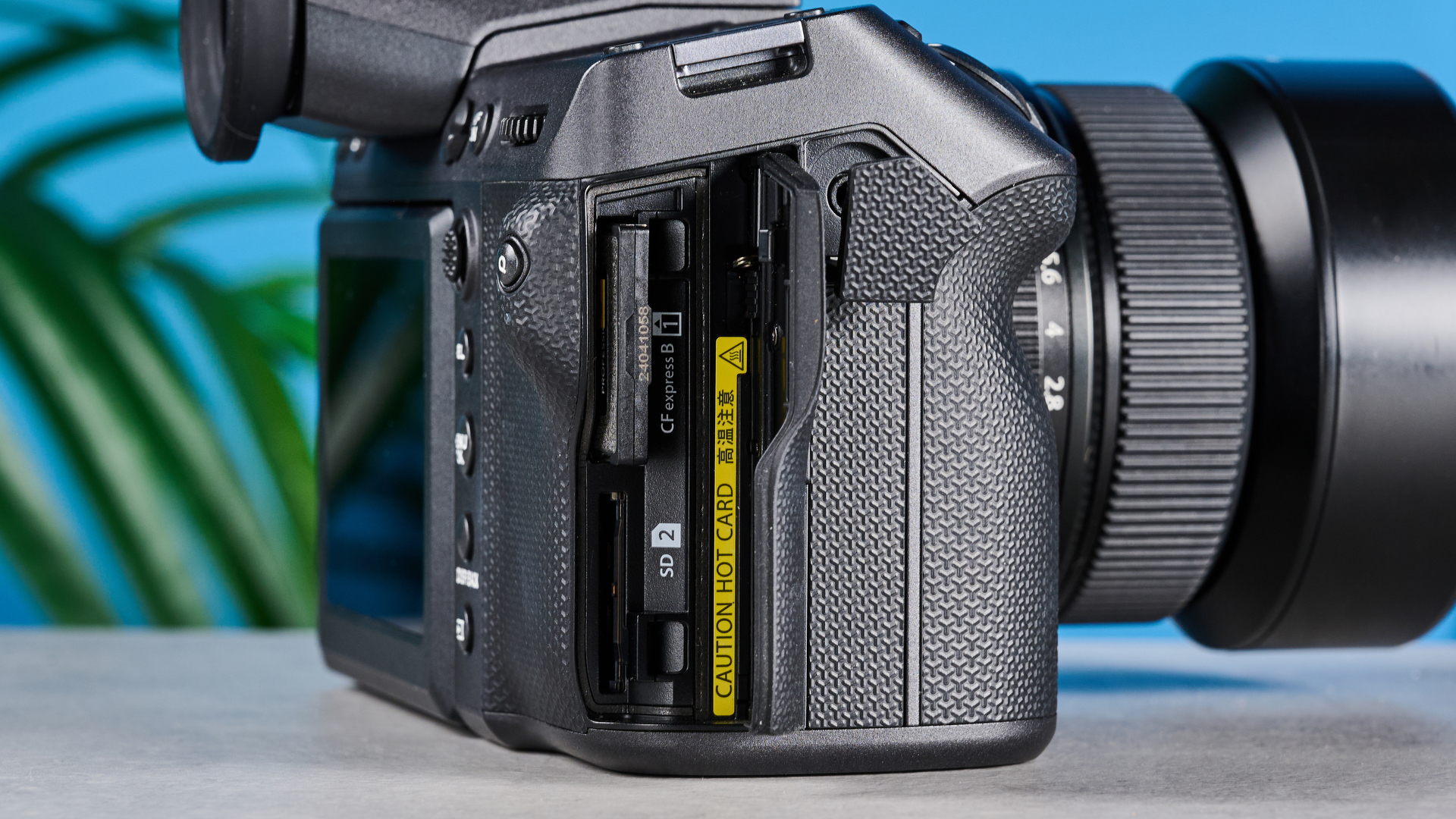 The Fujifilm GFX100 II with its card hatch open and card ports on display